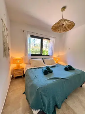 a bedroom with a large bed with a blue blanket at Villa Félicita 8 personnes proche plage Corse du sud in Lecci