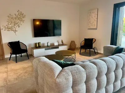 a living room with a couch and chairs and a tv at Villa Félicita 8 personnes proche plage Corse du sud in Lecci