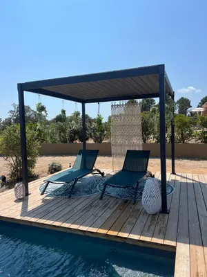 two chairs and a gazebo next to a pool at Villa Félicita 8 personnes proche plage Corse du sud in Lecci