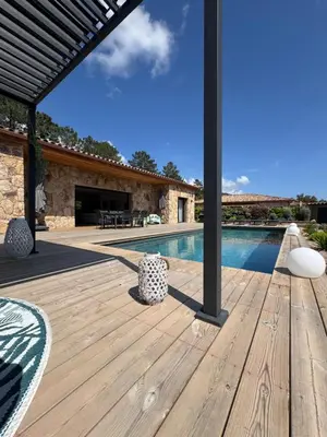 an outdoor patio with a wooden deck and a swimming pool at Villa Félicita 8 personnes proche plage Corse du sud in Lecci