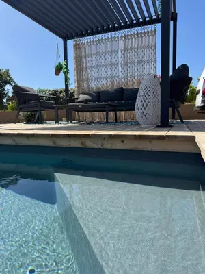a swimming pool with a pergola and a table and chairs at Villa Félicita 8 personnes proche plage Corse du sud in Lecci
