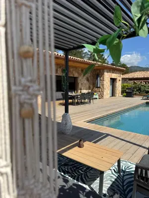 a patio with a table and a swimming pool at Villa Félicita 8 personnes proche plage Corse du sud in Lecci