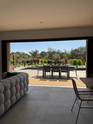 a living room with a large sliding glass door with a table and chairs at Villa Félicita 8 personnes proche plage Corse du sud in Lecci