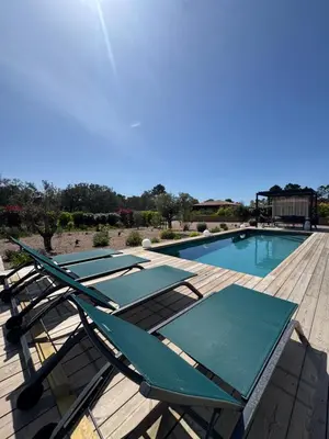 a row of lounge chairs next to a swimming pool at Villa Félicita 8 personnes proche plage Corse du sud in Lecci