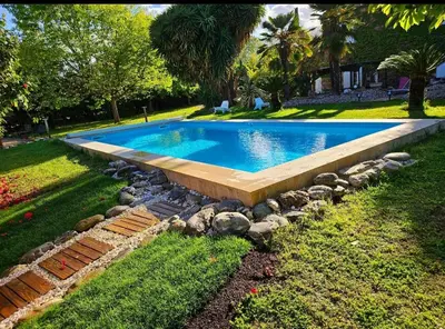 a swimming pool in a yard with rocks around it at La Casalamadonna in Santa-Lucia-di-Moriani
