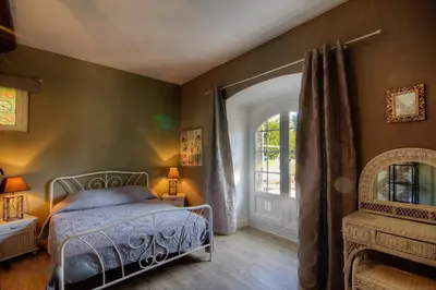 a bedroom with a bed and a window at La Casalamadonna in Santa-Lucia-di-Moriani