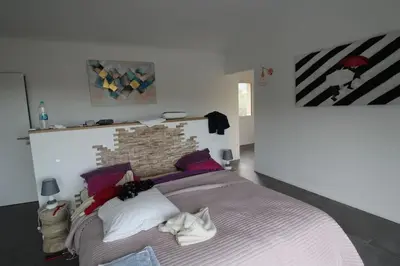 a bedroom with a large bed with a brick wall at Villa ALPANNA in Cirendinu