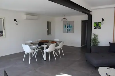 a living room with a table and chairs and a couch at Villa ALPANNA in Cirendinu