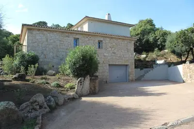 a stone house with a garage in front of it at Villa ALPANNA in Cirendinu