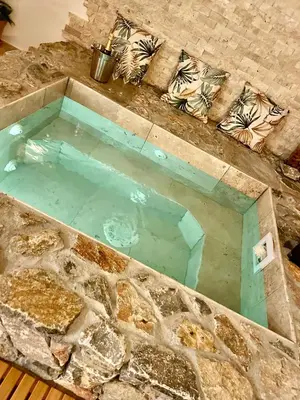 a large pool of water in a stone tub at I pozzi jacuzzi furiani love room haute corse in Furiani