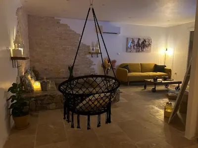 a living room with a couch and a chair at I pozzi jacuzzi furiani love room haute corse in Furiani