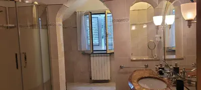 a bathroom with a sink and a toilet and a window at Villa des fleurs in Ortale