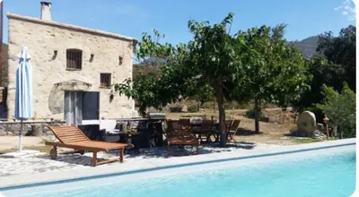 a house and a swimming pool next to a building at La Casetta in Castifao