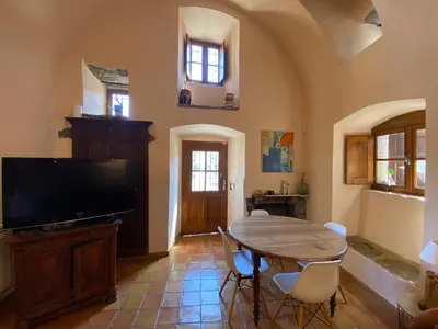 a dining room with a table and a tv at La Casetta in Castifao