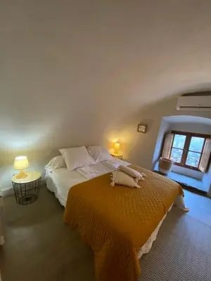 a bedroom with a bed with an orange blanket at La Casetta in Castifao