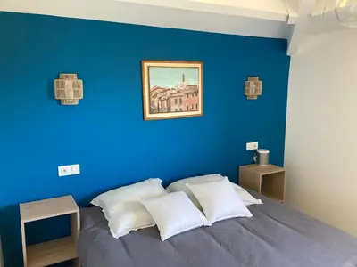 a blue bedroom with a bed with white pillows at Duplex terrasse vue mer in Pisinale