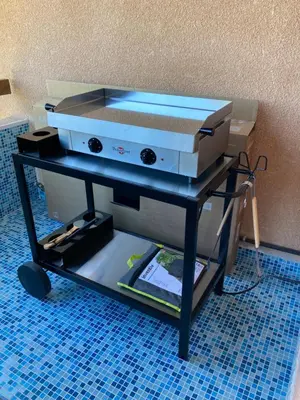 a grill sitting on a cart with a table at Duplex terrasse vue mer in Pisinale