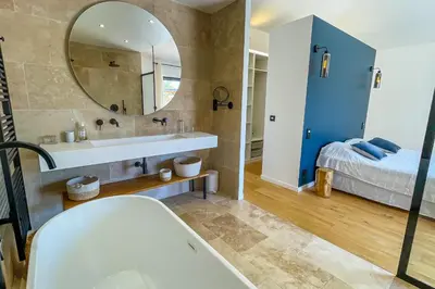 a bathroom with a tub and a mirror and a bed at Villa A Calia di Fiori Mare in Sainte-Lucie de Porto-Vecchio