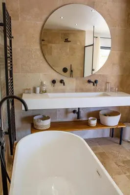a bathroom with a tub and a large mirror at Villa A Calia di Fiori Mare in Sainte-Lucie de Porto-Vecchio