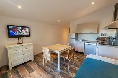 a small kitchen with a table and a kitchenette with a dining room at Royal Palm in Porto-Vecchio