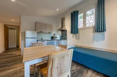 a kitchen and dining room with a wooden table at Royal Palm in Porto-Vecchio