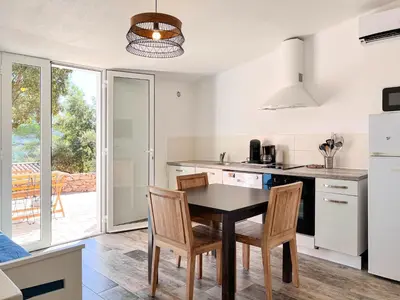 a kitchen with a dining room table and chairs at Royal Palm in Porto-Vecchio