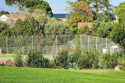 a fence in front of a tennis court at Mini villa Favone in Conca