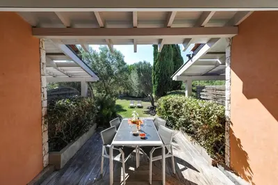 a patio with a table and chairs under a pergola at Studio Kalliste - Vision Luxe in Bonifacio