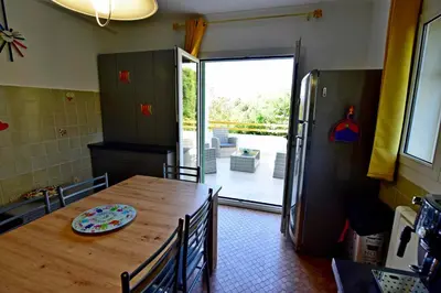 a kitchen with a wooden table and a refrigerator at Maison Capanelli in Casa delle Torre