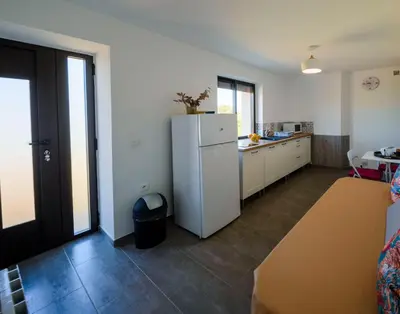 a kitchen with a white refrigerator in a room at Casa Kallinina in Esigna