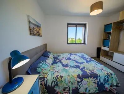 a bedroom with a bed and a desk with a lamp at Casa Kallinina in Esigna