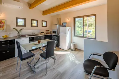 a kitchen with a table and chairs and a refrigerator at Casa Kallinina in Esigna
