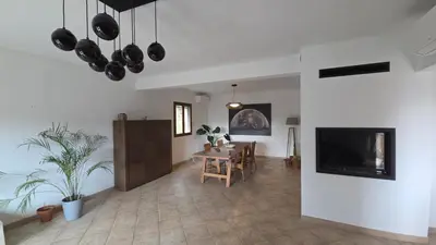 a living room with a table and a tv at Maison agréable avec grands volumes in Levie