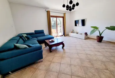 a living room with a blue couch and a table at Maison agréable avec grands volumes in Levie