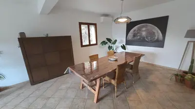 a dining room with a wooden table and chairs at Maison agréable avec grands volumes in Levie