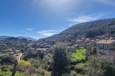 a village on a hill with houses and a mountain at Maison agréable avec grands volumes in Levie