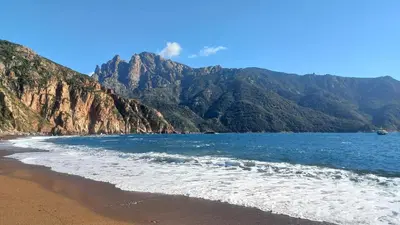 a view of a beach with mountains in the background at A casa di Francesca in Marignana