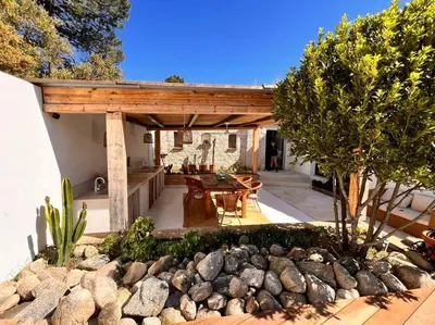 a backyard with a wooden pergola and a table and chairs at Casa Brahma pour 8 personnes -Porto Vecchio in San-Gavino-di-Carbini