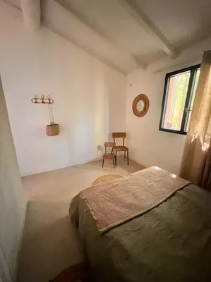 a bedroom with a bed and a chair in it at Casa Brahma pour 8 personnes -Porto Vecchio in San-Gavino-di-Carbini