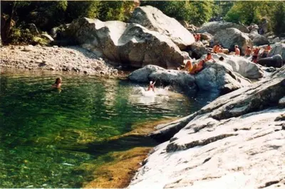a group of people swimming in a body of water at Bas de villa avec piscine in Moltifao