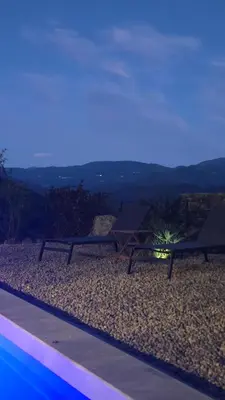 two benches sitting on top of a hill at night at Bas de villa avec piscine in Moltifao