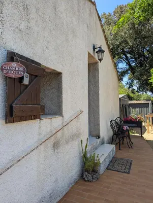 a sign on the side of a building with a patio at La chambre de Ptitruc au coeur du maquis in Granace