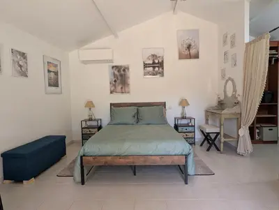 a bedroom with a bed with a blue bedspread at La chambre de Ptitruc au coeur du maquis in Granace