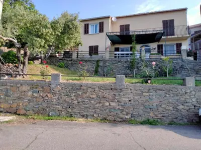 a stone retaining wall in front of a house at Maison de village corse in Campitello