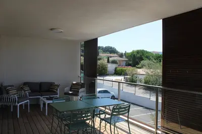 a balcony with a table and chairs and a view at A Cardellina in Porticcio