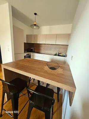 a kitchen with a wooden table and black chairs at A Cardellina in Porticcio