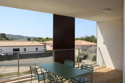 a table and chairs on a balcony with a view at A Cardellina in Porticcio