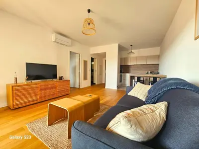 a living room with a blue couch and a tv at A Cardellina in Porticcio