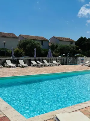 a swimming pool with lounge chairs and umbrellas at Mini villa piscine et plage in Cervione