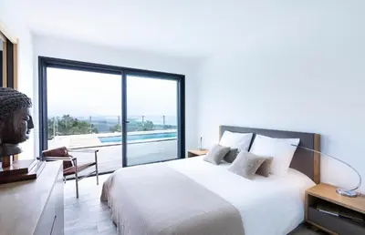 a bedroom with a large bed and a large window at a STELLA DI FOCE in Kamiesch